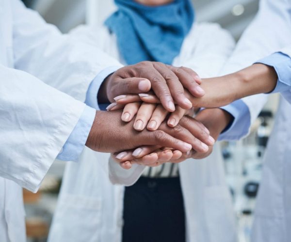 A group of doctors with hands placed on eachother
